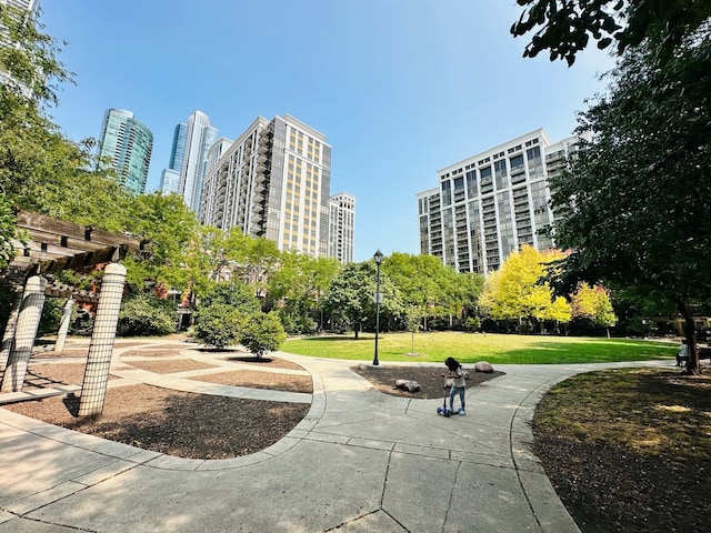 view of community featuring a yard and a pergola