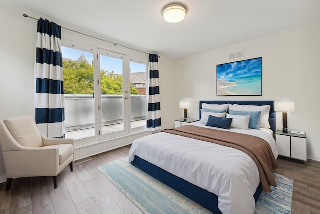 bedroom with access to outside and hardwood / wood-style floors