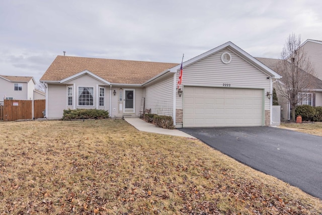 ranch-style house with a front yard, fence, driveway, a shingled roof, and a garage