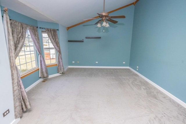 carpeted spare room featuring ceiling fan, baseboards, and vaulted ceiling