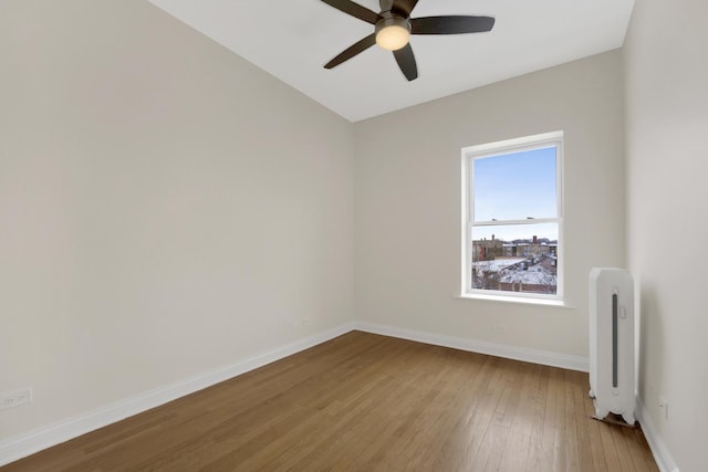 unfurnished room featuring ceiling fan, wood-type flooring, and radiator