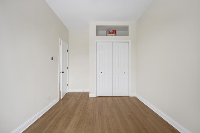 unfurnished bedroom featuring wood-type flooring and a closet