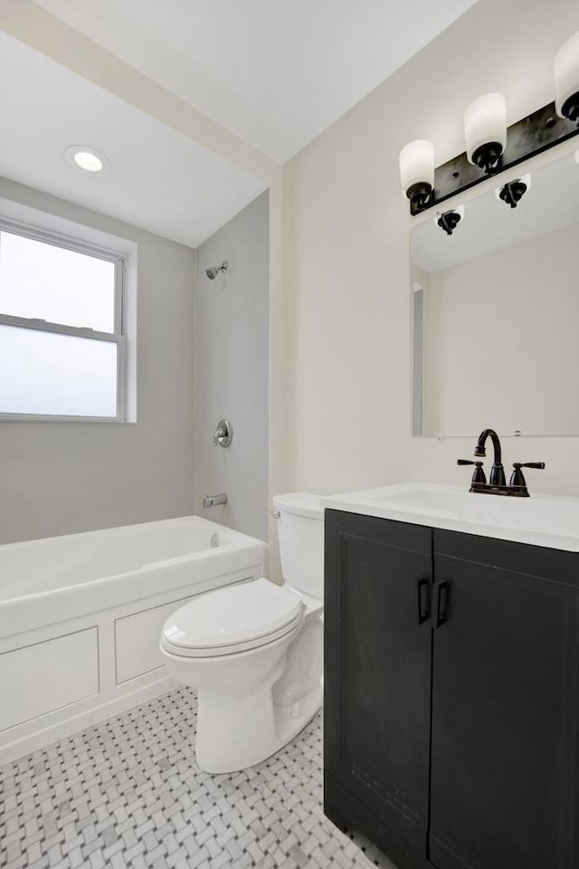 full bathroom with vanity, tiled shower / bath, and toilet