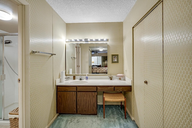 bathroom featuring an enclosed shower, vanity, and a textured ceiling