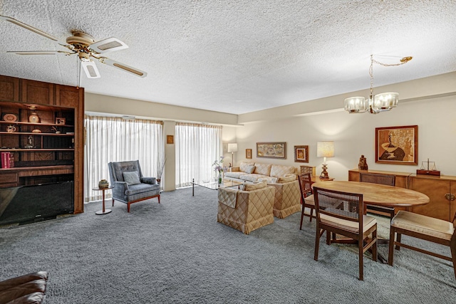 living room featuring carpet flooring, ceiling fan with notable chandelier, and a textured ceiling