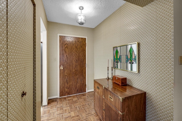 entryway with light parquet floors and a textured ceiling