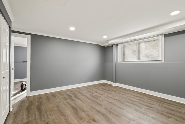 basement featuring hardwood / wood-style flooring and crown molding