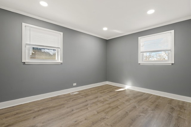 unfurnished room featuring ornamental molding and light hardwood / wood-style floors