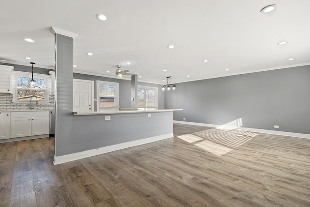 kitchen featuring white cabinetry, tasteful backsplash, wood-type flooring, pendant lighting, and ceiling fan