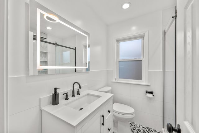 bathroom featuring vanity, toilet, tile walls, and a shower with shower door