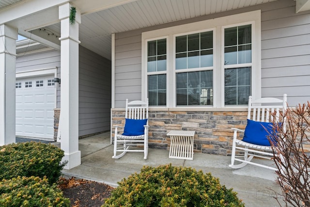 view of patio featuring covered porch and a garage