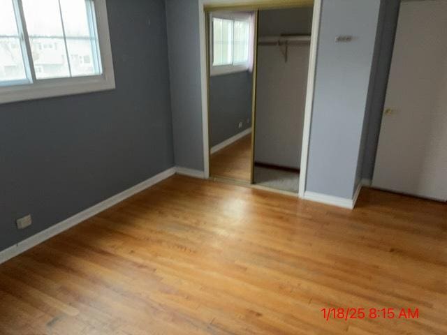 unfurnished bedroom with wood-type flooring and a closet