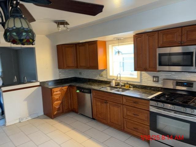 kitchen featuring appliances with stainless steel finishes, sink, and decorative backsplash