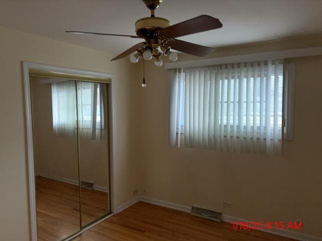 unfurnished bedroom with hardwood / wood-style flooring, a closet, and ceiling fan