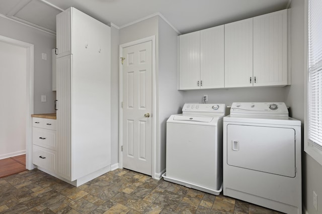 clothes washing area featuring washing machine and dryer and cabinets