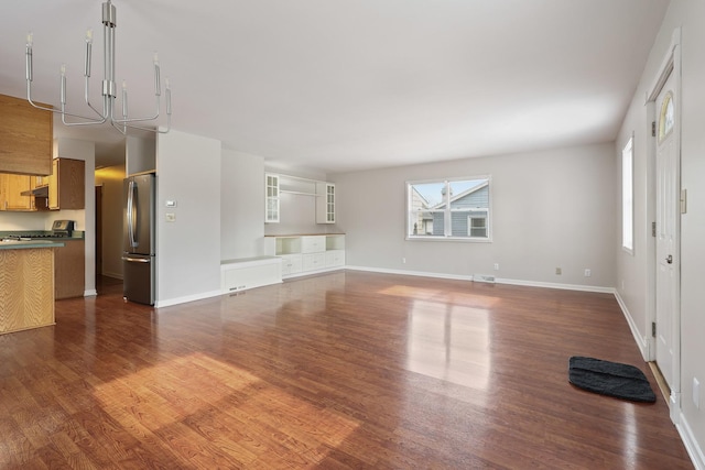 unfurnished living room featuring a wealth of natural light and dark hardwood / wood-style floors