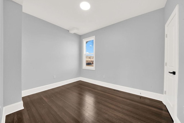 spare room with dark wood-type flooring