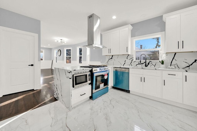 kitchen with white cabinetry, island range hood, kitchen peninsula, stainless steel appliances, and backsplash