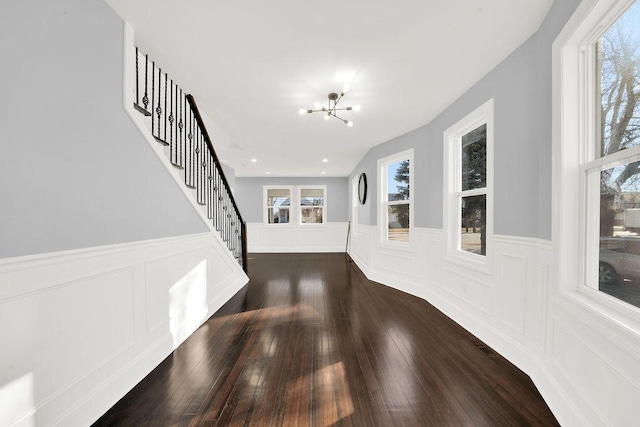 entryway with a healthy amount of sunlight, dark hardwood / wood-style flooring, and a chandelier