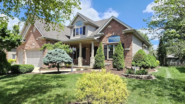 26357 S Lyndsay Dr, Channahon, IL 60410 - view of front of house featuring brick siding, a front yard, a shingled roof, a garage, and covered porch