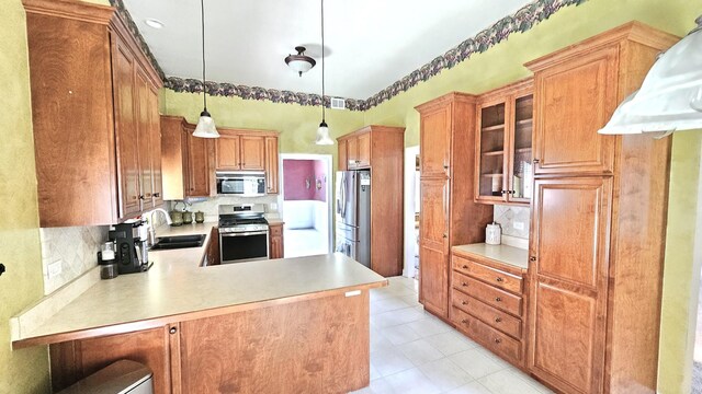 26357 S Lyndsay Dr, Channahon, IL 60410 - kitchen featuring appliances with stainless steel finishes, a sink, light countertops, tasteful backsplash, and a peninsula