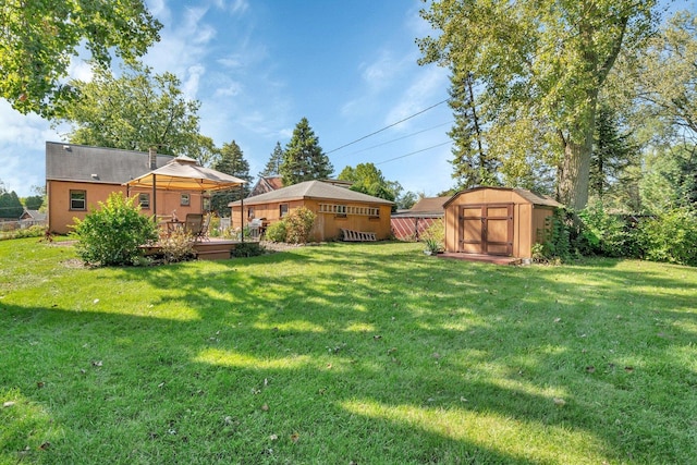 view of yard featuring a shed, a gazebo, and a deck