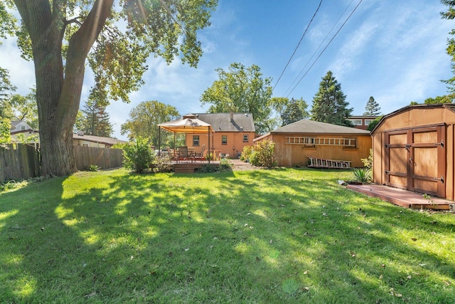 view of yard featuring a wooden deck, a gazebo, and a storage shed