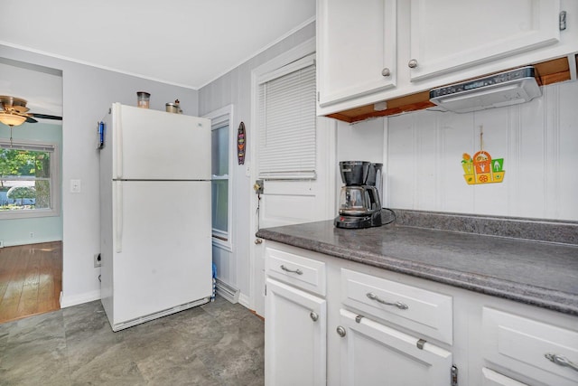 kitchen with white refrigerator, ceiling fan, ornamental molding, and white cabinets