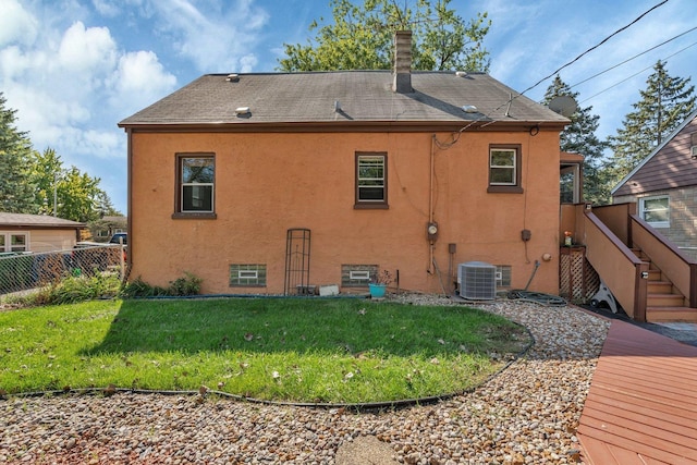 rear view of property with a wooden deck, a yard, and central air condition unit