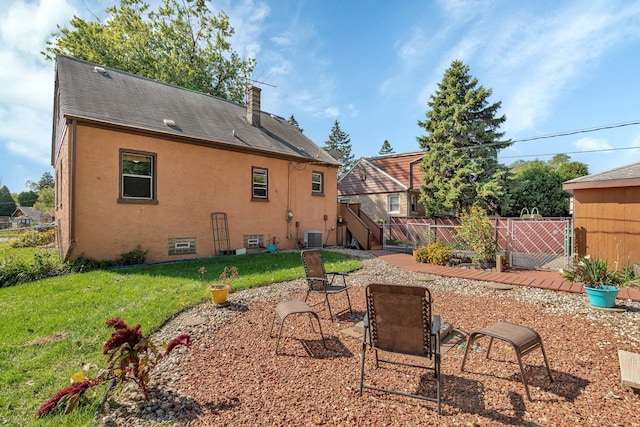 rear view of property with a yard, a patio area, and central air condition unit