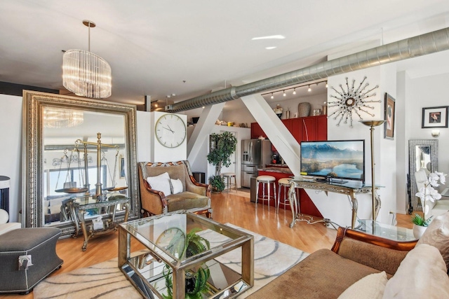 living room with a notable chandelier and light wood-type flooring