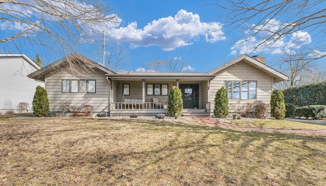 single story home featuring covered porch and a front yard