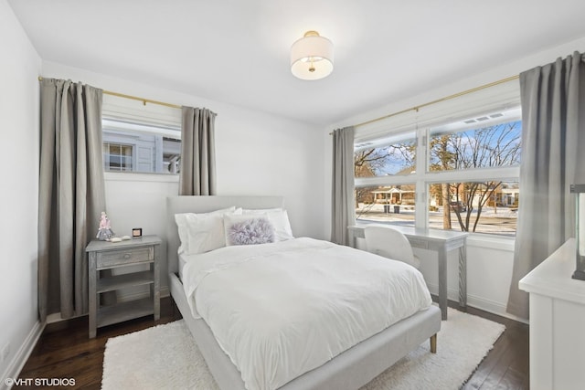 bedroom with dark hardwood / wood-style floors