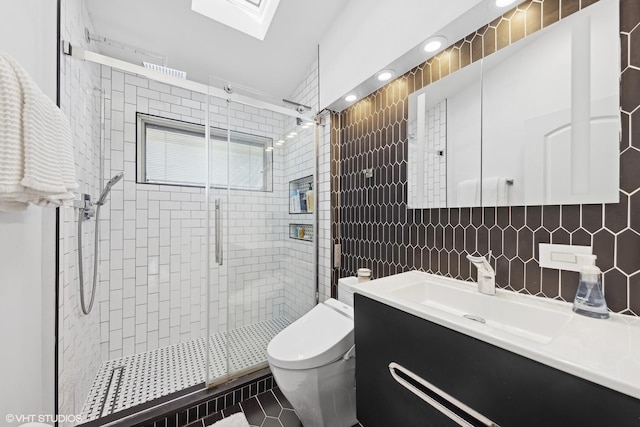 bathroom with tile patterned flooring, backsplash, vanity, toilet, and walk in shower