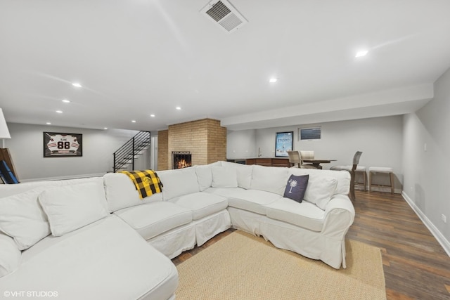 living room with hardwood / wood-style floors and a brick fireplace