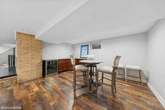 dining room with wine cooler, dark wood-type flooring, and bar area