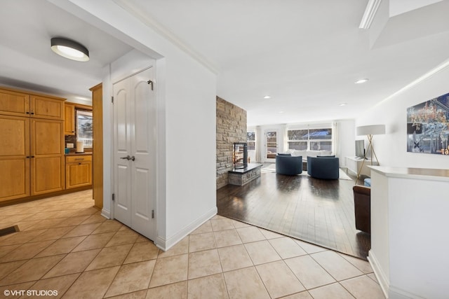 hallway with crown molding and light tile patterned floors