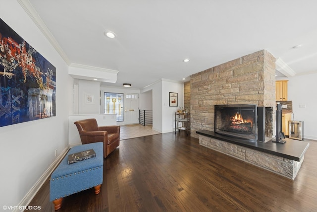 living room featuring crown molding, dark hardwood / wood-style floors, and a fireplace