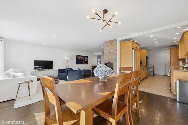 dining room with dark hardwood / wood-style floors, a notable chandelier, and a fireplace