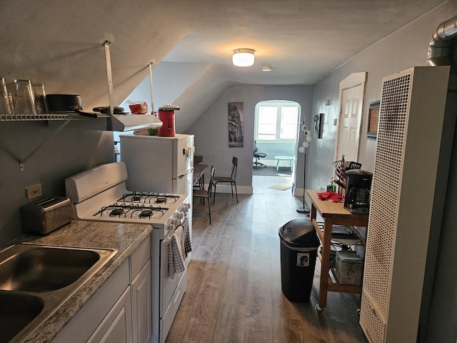 kitchen with hardwood / wood-style flooring, vaulted ceiling, white range with gas cooktop, and sink