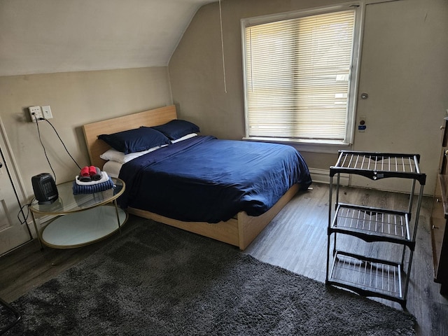 bedroom featuring hardwood / wood-style flooring and vaulted ceiling