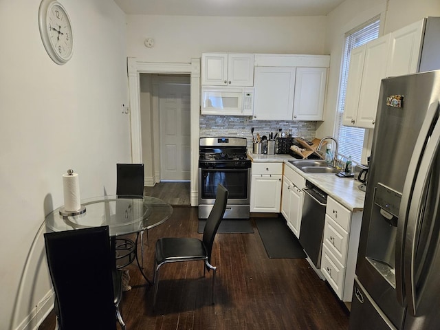 kitchen featuring sink, appliances with stainless steel finishes, dark hardwood / wood-style floors, decorative backsplash, and white cabinets