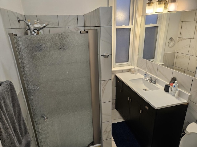 bathroom featuring vanity, an enclosed shower, tile walls, and backsplash