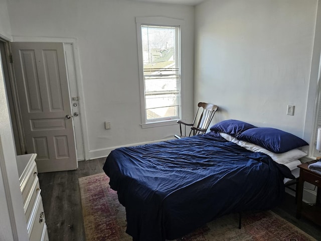 bedroom featuring multiple windows and dark wood-type flooring