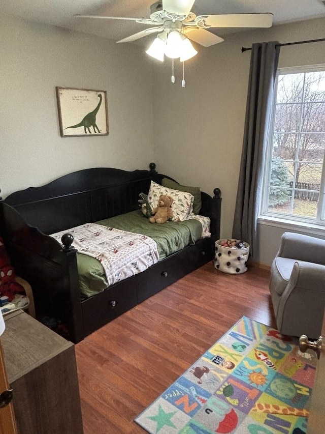 bedroom with dark hardwood / wood-style floors and ceiling fan