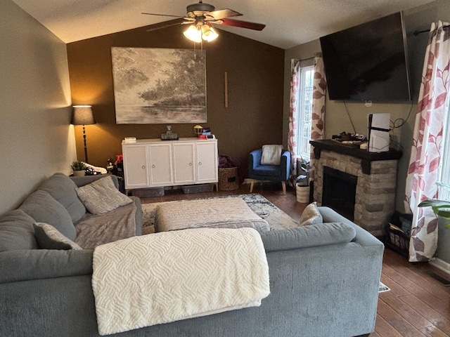 living room with vaulted ceiling, ceiling fan, dark hardwood / wood-style flooring, and a fireplace