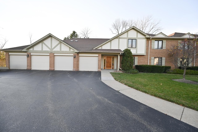 tudor-style house featuring a garage and a front yard