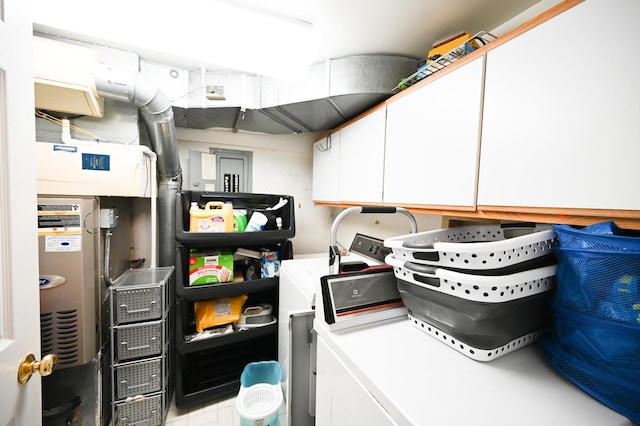 clothes washing area with cabinets and washer and clothes dryer