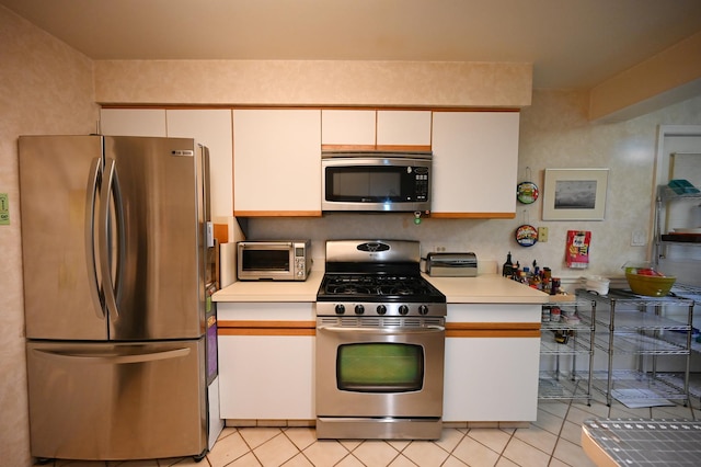 kitchen with white cabinetry, light tile patterned floors, and appliances with stainless steel finishes