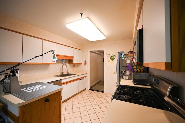 kitchen featuring light tile patterned floors, stainless steel appliances, sink, and white cabinets